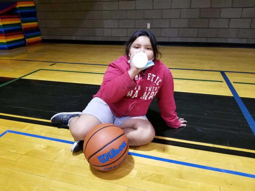 girl drinking water at basketball practice