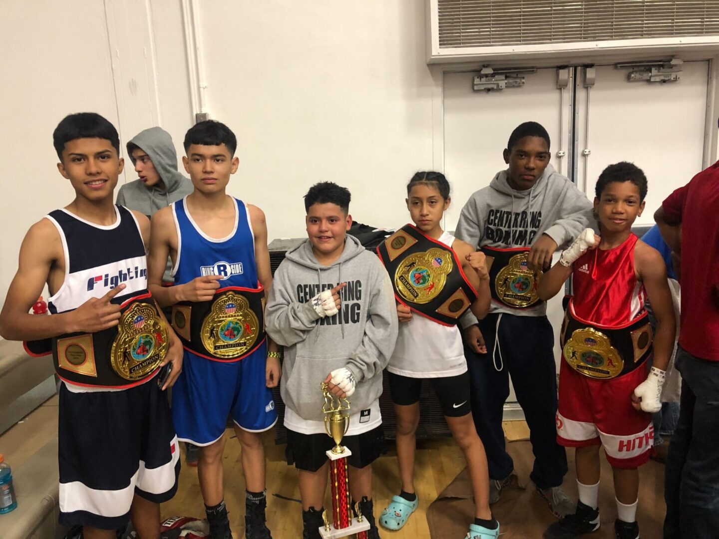 A Group of Boys Holding Awards in Boxing Gear